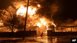 Lính cứu hỏa dập tắt một đám cháy sau vụ tấn công của Nga nhắm vào khu dân cư ở Kharkiv, Ukraine, ngày 10 tháng 2 năm 2024.