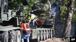 Công nhân dỡ bỏ chiếc xe tăng T-34 của Liên Xô được lắp làm tượng đài ở Narva, Estonia, ngày 16/8/2022. Cuộc xâm lược Ukraine của Nga đã dẫn đến làn sóng mới lật đổ những tượng đài cuối cùng còn sót lại của quân đội Liên Xô ở châu Âu.