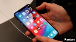 Một khách hàng thử một điện thoại tinh khôn trong thời gian tung ra iPhone XS và XS Max mới tại một cửa hàng của Apple ở Moscow, Nga, ngày 28/9/2018.