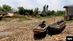 Hai chiếc xuồng nằm trên mặt đất nứt nẻ trong một vùng khô hạn tại tỉnh Cà Mau, Việt Nam. Việt Nam đang đối mặt với đợt hạn hán nghiêm trọng nhất trong 90 năm qua, theo một tuyên bố của Bộ Nông nghiệp và Phát triển Nông thôn. 
