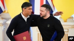 Thủ tướng Anh Rishi Sunak (trái) ôm Tổng thống Ukraine Volodymyr Zelenskyy sau khi ký các văn kiện ở Kyiv, Ukraine, ngày 12 tháng 1 năm 2024.