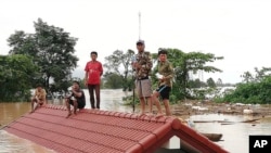 Người dân đứng trên một mái nhà ngập lụt sau khi sau khi đập thủy điện Xe-Pian Xe-Namnoy bị vỡ, ngày 24/7/2018.