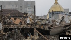 Một người dân địa phương dọn dẹp tại địa điểm nơi một tòa nhà chung cư bị phá hủy trong cuộc tấn công phi đạn của Nga, ở Odesa, Ukraine, ngày 29 tháng 12 năm 2023.
