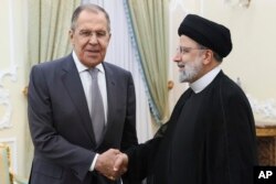 روسی وزیر خارجہ سرگئی لاروف تہران کے ایک دورے کے دوران ایرانی صدر ابراہیم رئئیسی سے ہاتھ ملا رہے ہیں ، فوٹو اے پی 23 اکتوبر 2023